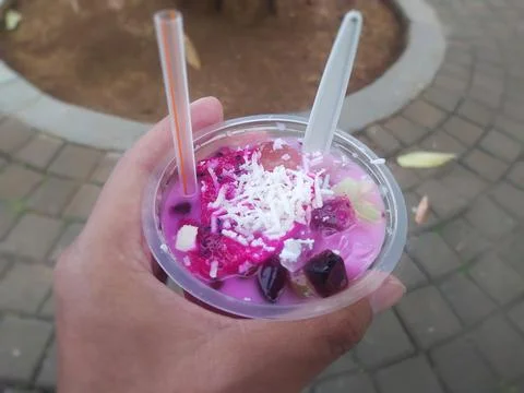 Refreshing dragon fruit ice drink with grated cheese sprinkled on it. Stock Photos