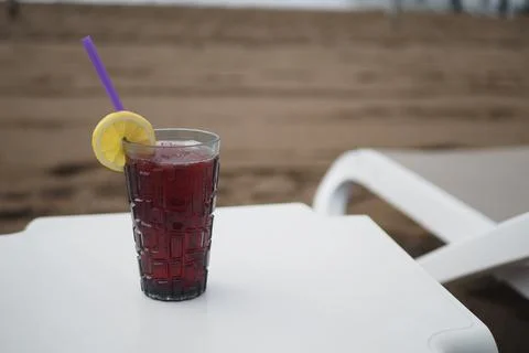 Refreshing drink on a beach table at sunset Stock Photos