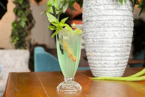 Refreshing drink in a cafe setting with greenery around Stock Photos