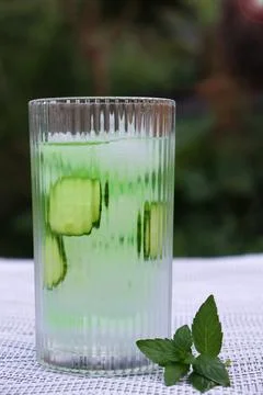 Refreshing drink with cucumber and mint on a table outdoors Stock Photos