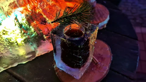 Refreshing Drink in Ice Glass with Pine Garnish Under Colorful Lights Stock Footage 328280952