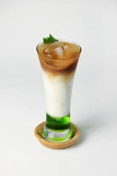 Refreshing drink layered with melon syrup, milk and coffee in a tall glass Stock Photos