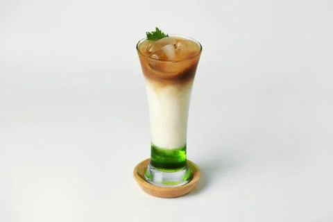 Refreshing drink layered with melon syrup, milk and coffee in a tall glass Stock Photos