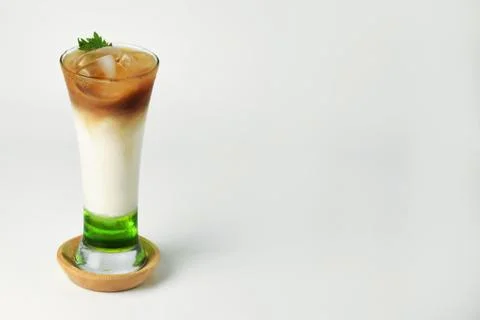 Refreshing drink layered with melon syrup, milk and coffee in a tall glass Stock Photos