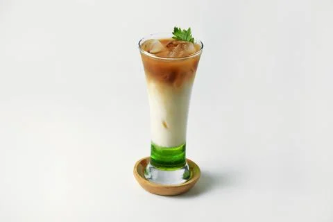 Refreshing drink layered with melon syrup, milk and coffee in a tall glass Stock Photos