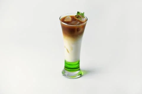 Refreshing drink layered with melon syrup, milk and coffee in a tall glass Stock Photos