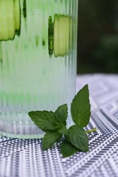 Refreshing drink with mint and cucumber on a patterned tablecloth in a garden Stockfoto's
