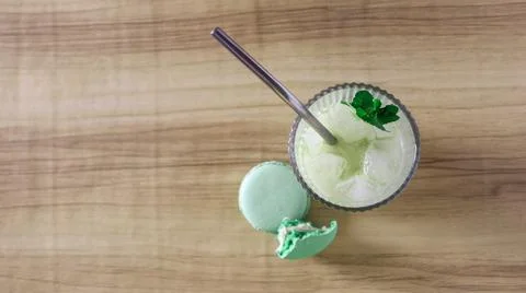 Refreshing drink with mint and a macaroon on a wooden table Stock Photos