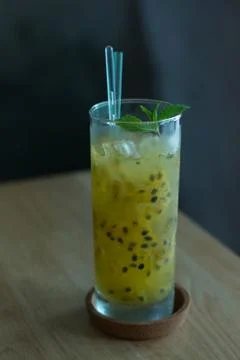 Refreshing drink of Passion fruit, lime, mint in a tall glass Stock Photos