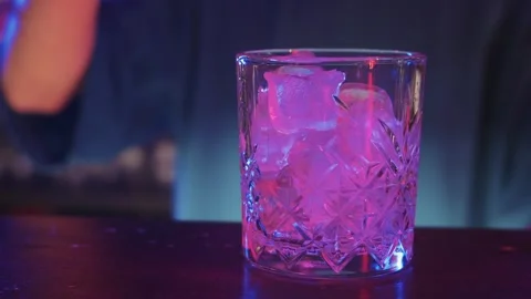 A Refreshing Drink on the Table with a Skilled Bartender in the Background Stock Footage 255014388