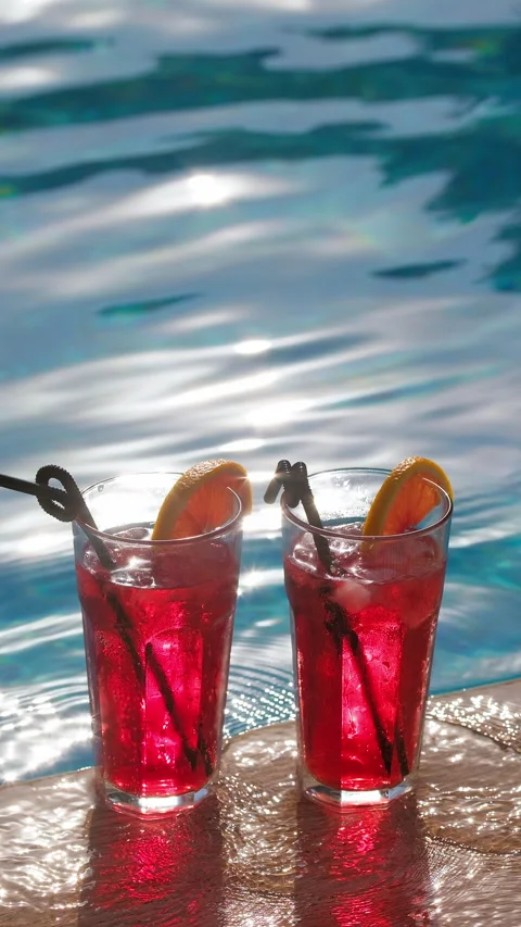 Refreshing drinks in a glasses near swimming pool Stock Footage 314564532
