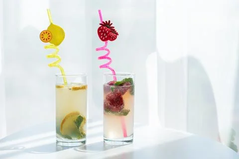 Refreshing drinks with lemon and strawberry in glasses Stock Photos