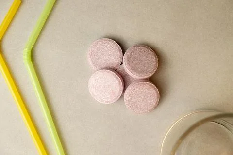 Refreshing effervescent tablets ready to dissolve in a glass of water Stock Photos