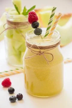 Refreshing fruit beverages served in jars featuring vibrant garnishes of berries Stock Photos