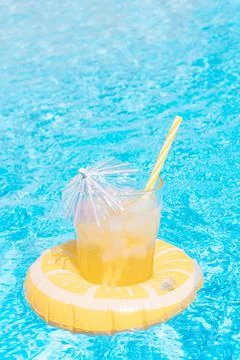 A refreshing fruit juice inside a lemon inflatable by the pool. summer concep Stock Photos
