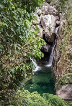 Refreshing Green Waterfall Bath in Remote Tropical Rainforest Foto stock