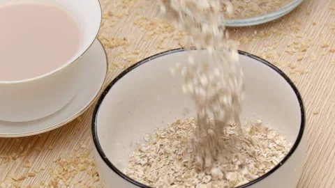 A refreshing healthy breakfast scene with pouring seeds cereal into a bowl 스톡 동영상 331394586