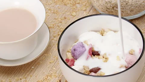 A refreshing healthy breakfast scene with white milk or creamy yogurt pouring Vídeos de archivo 331384024