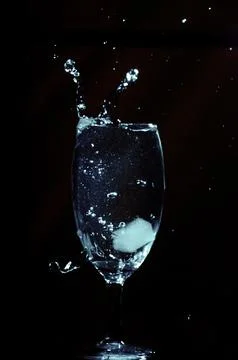Refreshing ice cubes floating in a clear drink glas Stock Photos