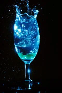 Refreshing ice cubes floating in a clear drink glas Stock Photos