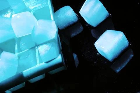 Refreshing ice cubes floating in a clear drink glas Stock Photos