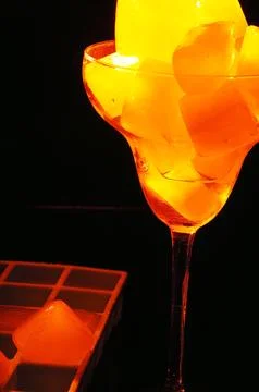 Refreshing ice cubes floating in a clear drink glas Stock Photos