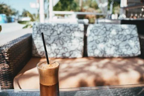 A refreshing iced coffee drink served in a tall glass at a cafe terrace Stock Photos