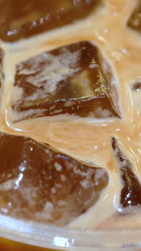 Refreshing iced coffee with ice cubes. Close-up texture of iced coffee. Stock Footage 304493784