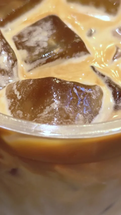 Refreshing iced coffee with ice cubes. Close-up texture of iced coffee. Stock Footage 304592982