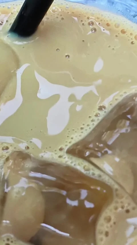 Refreshing iced coffee with ice cubes. Close-up texture of iced coffee. Stock Footage 313682411