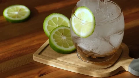A refreshing iced lemon soda in the heat and after a meal. man pouring drink int Vídeo Stock 155698546