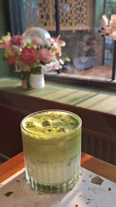 Refreshing iced matcha latte in a cozy cafe Vídeos de archivo 340118450