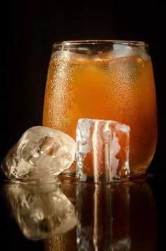Refreshing iced tamarind drink served in a glass with clear ice cubes. Stock Photos