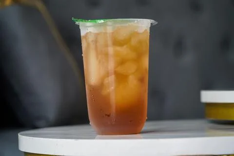Refreshing Iced Tea in a Clear Plastic Cup on a White Table Stock Photos
