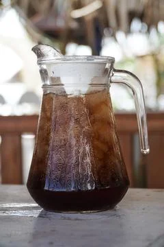 Refreshing Iced Tea in a Glass Pitcher with Condensation on an Outdoor Table Stock Photos