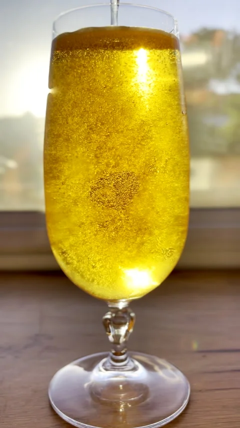 Refreshing lager beer poured into beer glass creating bubbles Stock Footage 345620836