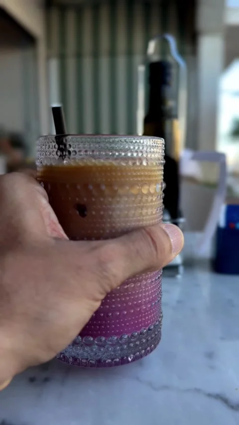 Refreshing layered Ube latte beverage in a decorative glass, close-up shot Stock Footage 339916040
