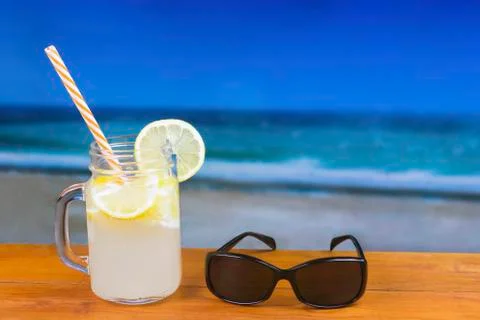 Refreshing Lemon Drink on a Table Against the Sea 写真素材