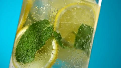 Refreshing lemonade with mint and ice in glass on a blue background Stock Photos