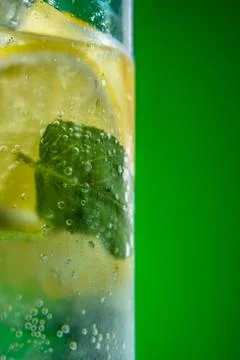 Refreshing lemonade with mint and ice in glass on green background Stock Photos
