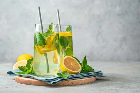 Refreshing lemonade with mint on a gray background. An invigorating summer dr Stock Photos