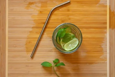 Refreshing lemonade with mint, lime and ice in a glass jar with a metal straw Photos