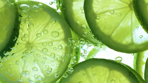 Refreshing lime slices sparkling in clear water with rising bubbles. Stock Footage 337351046