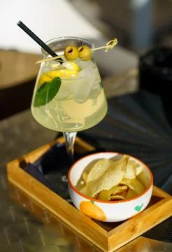 Refreshing Limoncello Spritz with Lemon Mint and Olives and Potato Chips Fotos de archivo