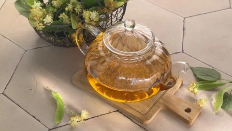 Refreshing linden blossom herbal tea steeping in glass teapot Stock Footage 340265737
