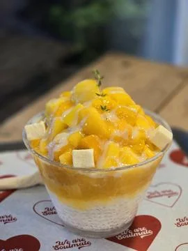 Refreshing mango bingsu with fluffy shaved ice, sweet mango chunks, and cre.. Stock Photos