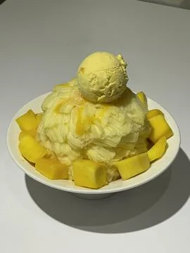 Refreshing mango bingsu with fluffy shaved ice, sweet mango chunks, and cre.. Stock Photos