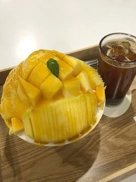 Refreshing mango bingsu with fluffy shaved ice, sweet mango chunks, and cre.. Stock Photos