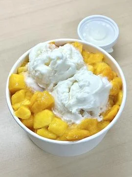 Refreshing mango bingsu with fluffy shaved ice, sweet mango chunks, and cre.. Stock Photos