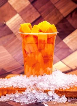 Refreshing Mango Chunks Bricks with Crushed Ice served in plastic cup isola.. Stock Photos